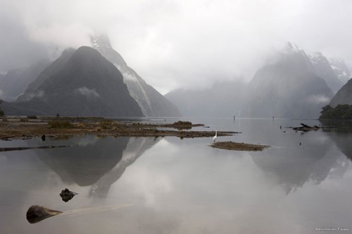 Clouded peaks and still water create the perfect reflection at Milford Sound.