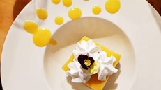 A lemon tart plated with cream and pansies at Milford Sound Lodge's Pio Pio Restaurant.